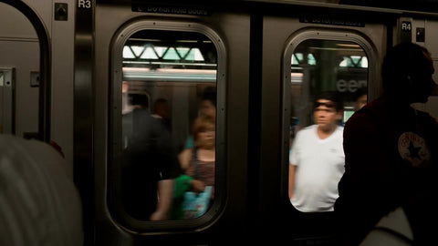 subway train coming to stop at elevated station in summer in NYC