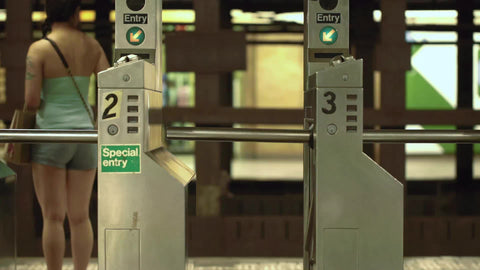 express subway train - station turnstiles with special entry sign with audio in NYC summer