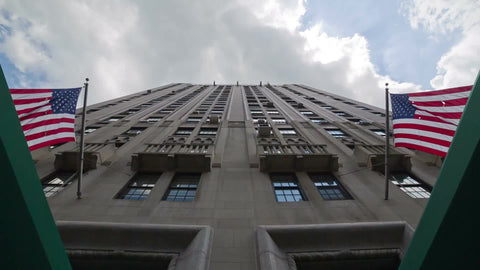 upward angle of 1 5th Avenue - tall building with American flags in Manhattan NYC
