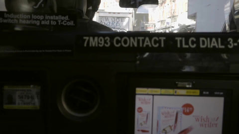taxi cab interior from backseat - driver and meter driving behind graffiti truck on lower east side
