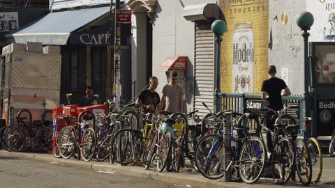 Bedford Ave subway station entrance for L train in Williamsburg Brooklyn with parked bicycles in New York City on summer day