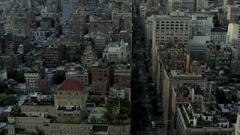 Empire State Building in early evening day aerial flying over buildings Manhattan New York City NYC