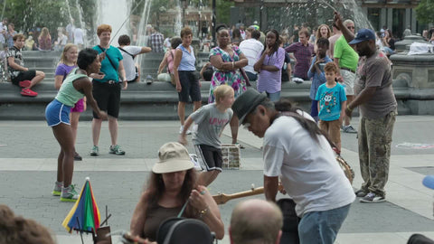 blonde kid playing Double Dutch in Washington Square Park on summer day