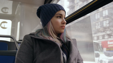 beautiful woman riding MTA bus on gloomy cold winter day - passenger looking out window in 4K NYC slow motion - contact us for model details