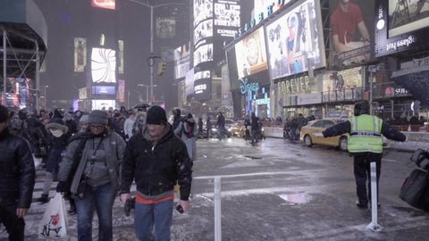 people walking in snow at night in Times Square crosswalk, slow motion NYC