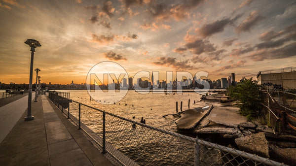 Manhattan skyline with gritty view of junk and broken down garbage in Brooklyn across East River at sunset