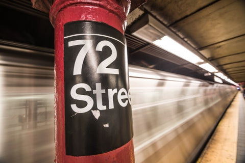 72nd street subway sign on platform pillar with blurred motion train entering station in NYC