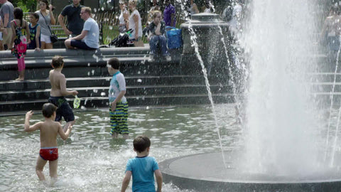 kids playing in water sprinkler - fountain in Washington Square Park on summer day in NYC