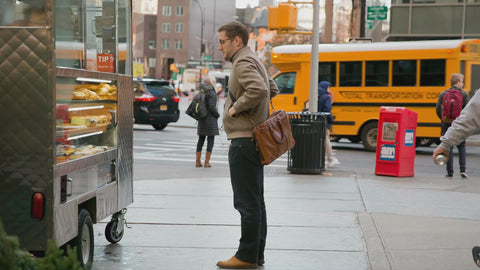 man putting on gloves at food cart in Cooper Square and school bus NYC