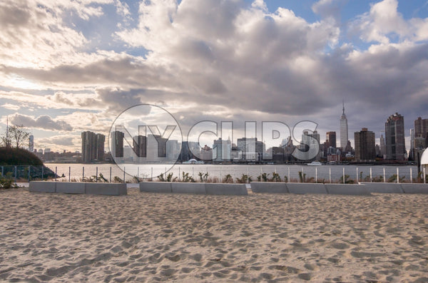 Manhattan skyline from sand - beach in Brooklyn with beautiful blue sky and clouds on summer day