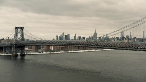 aerial toward Williamsburg Bridge and Empire State Building lateral tracking aerial drone shot with Manhattan skyline over East River New York City NYC