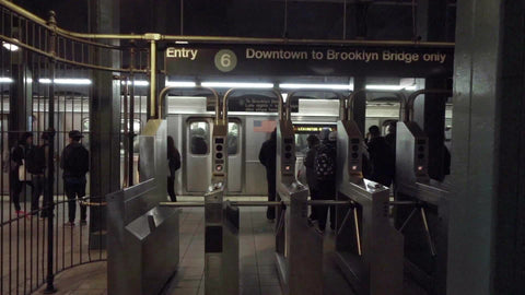 entry to 6 downtown to Brooklyn Bridge only sign from turnstiles in subway train station in slow motion in 1080 HD NYC