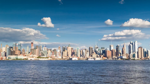 Manhattan skyline from across East River water with famous skyscrapers from day to night - 24 hour 4K timelapse