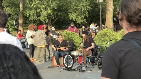 crowd watching live band playing music - guitar and drums - drummer in Washington Square Park NYC