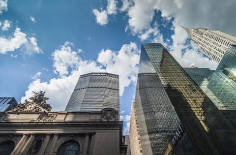 Grand Central Station Terminal with MetLife Building and Chrysler skyscraper towering over Midtown Manhattan on beautiful day - blue sky and clouds