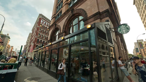 Starbucks in Cooper Square and Astor Place, panning on summer day with people outside in NYC