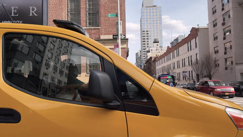driving past yellow taxi cab caravan with Tiger Woods ad Manhattan New York City NYC