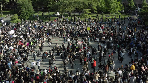 protestors gather in crowd to protest with signs in NYC
