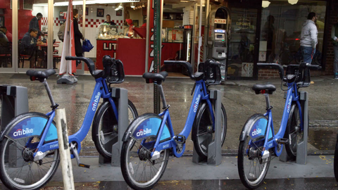 CitiBikes parked at docking station on street - 4K slow motion tracking of blue bicycles