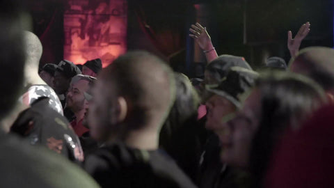 hip hop fans with hats backwards watching rap show in concert
