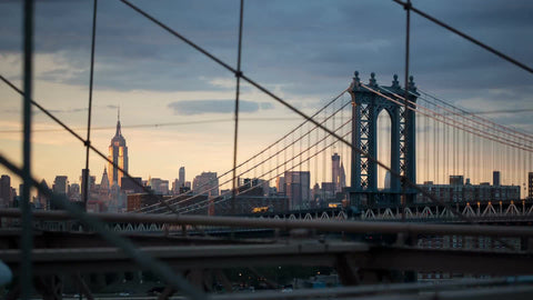 Manhattan Bridge and Empire State Building view from Brooklyn Bridge at beautiful sunset in early evening in NYC