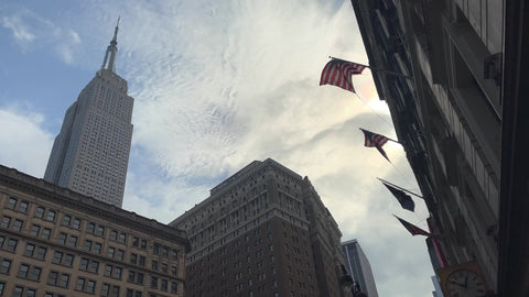 Empire State Building street view American flag - flag waving in Herald Square 34th Street Manhattan New York City NYC