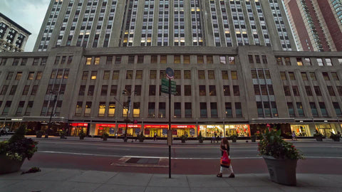 street view of 34th st tilting up to Empire State Building towering overhead