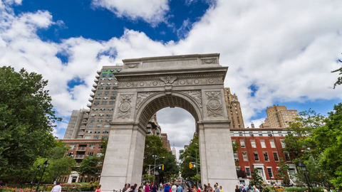 Washington Square Park arch and people in summer with beautiful blue sky and clouds - 4K timelapse in Greenwich Village NYC