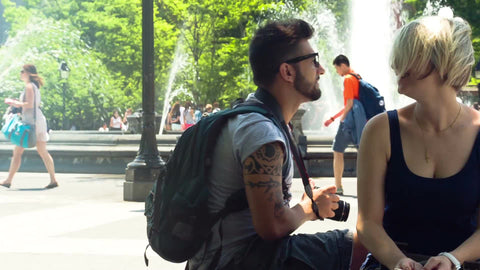 photographer couple in Washington Square Park on summer day in front of water sprinkler in NYC