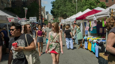 people enjoying beautiful summer day at street fair in New York City