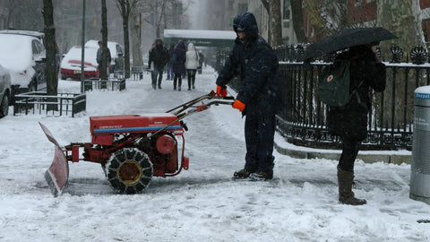 man operating snow plow in winter blizzard