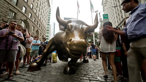 tourists at Wall Street Bull Sculpture in Financial district on summer day in Manhattan NYC