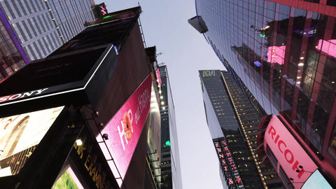 upward angle in Times Square in early evening - driving through billboards and ads in New York City