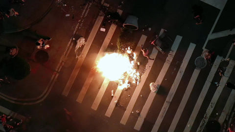 man lighting fire in street on crosswalk at night in New York City 1080