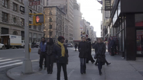taxi turning corner on 5th Ave on winter day with people walking, slow motion in NYC
