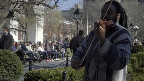 man playing violin in Washington Square Park in fall sunny day NYC