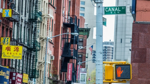 Canal Street sign on corner in Chinatown with Chinese signs in background in Manhattan NYC