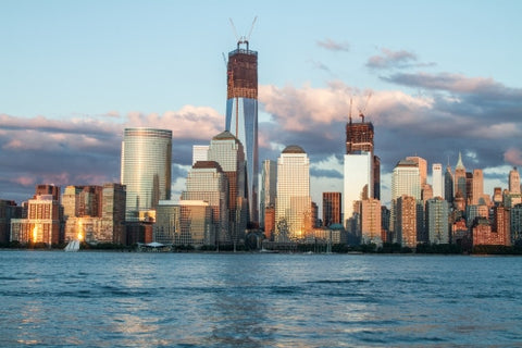 Freedom Tower under construction in Manhattan skyline in early evening from across East River water