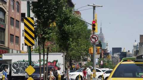 graffiti truck on Houston Street on summer day in Manhattan with Empire State Building in background