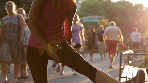 woman stretching in Central Park - jogger ready for run - silhouette of female athlete in sun on bright sunny day in late afternoon