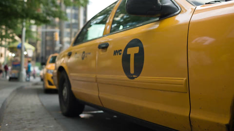 woman getting into cab at Columbus Circle - low angle of taxi stand on sunny day in NYC