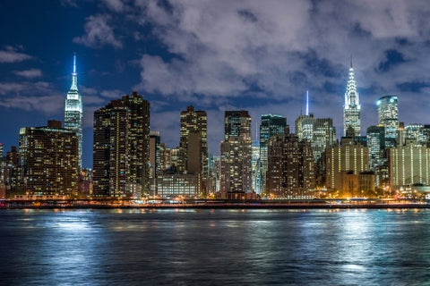 Empire State Building and Chrysler famous skyscrapers in Manhattan skyline from across East River water at night