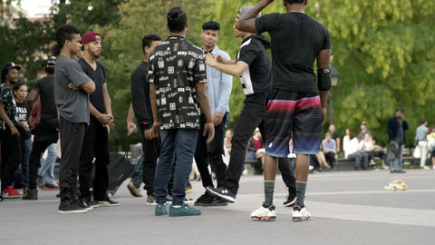 breakdancing spinning around in circle of dancers on summer day in Washington Square Park in NYC