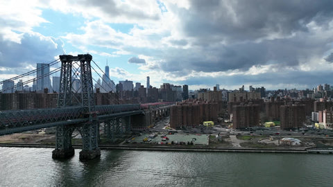 aerial approaching Manhattan alongside Williamsburg Bridge in NYC