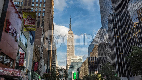 Empire State Building view from 34th Street and the west side of Manhattan on summer day with bright blue sky
