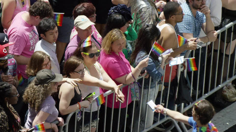 gay pride day - LGBT parade barricade with people waving rainbow flags in NYC