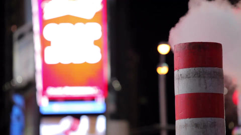 noisy Times Square at night with construction pipe blowing smoke - steam