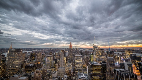 Empire State Building and Manhattan cityscape with skyscrapers from high view - cloudy sunset in early evening