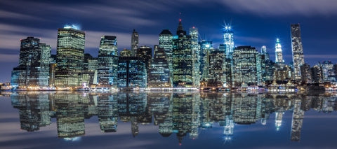 Manhattan skyline with unfinished Freedom Tower under construction at night across East River in HDR