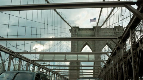 American flag on top of Brooklyn Bridge - view from car driving across in NYC